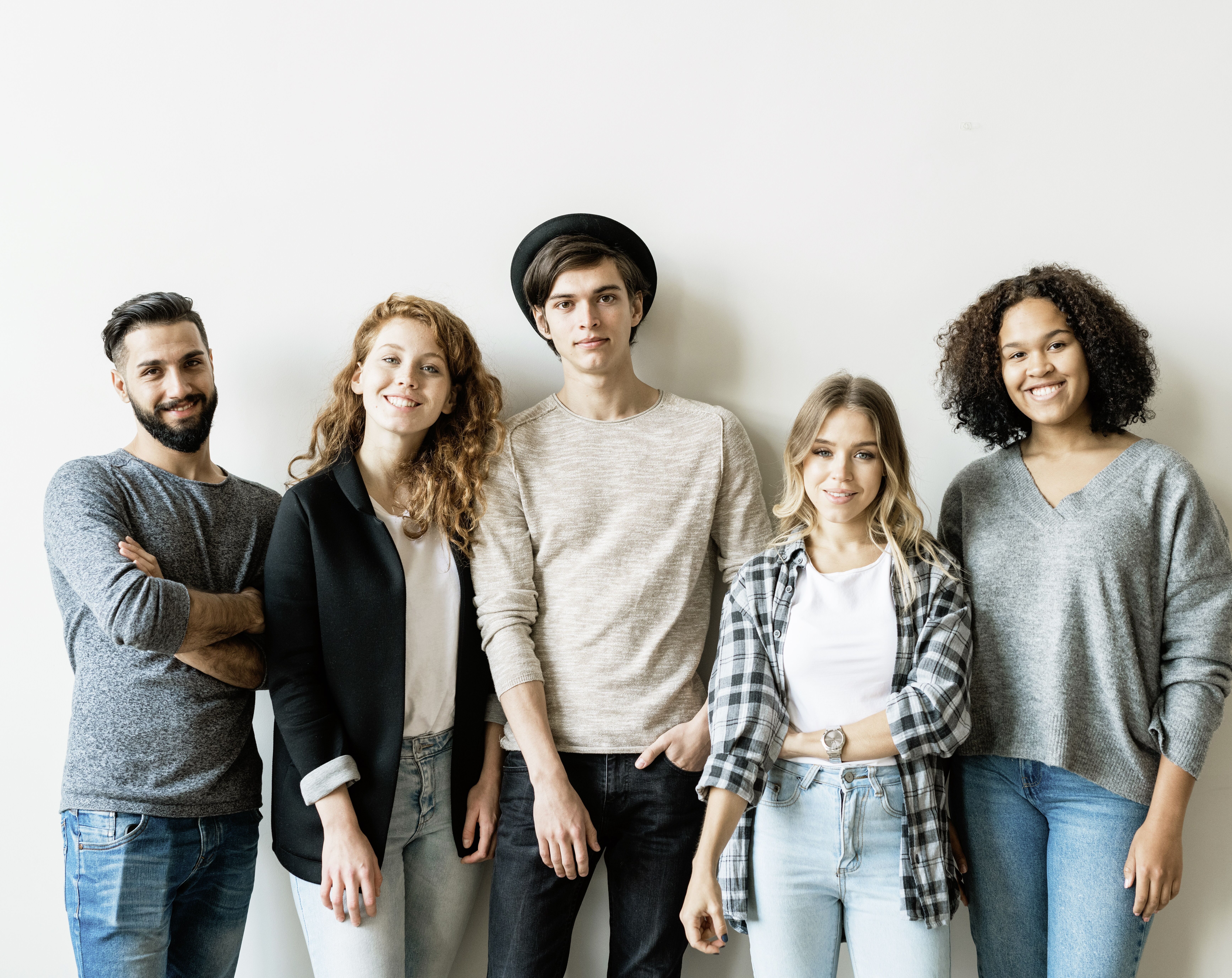 Eine Grupppe von Jugendlichen und jungen Erwachsenen steht zufireden als Gruppe zusammen.