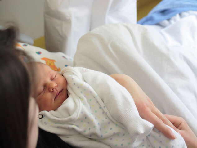 Mutter hält ein frisch geborenes Kind auf dem Arm