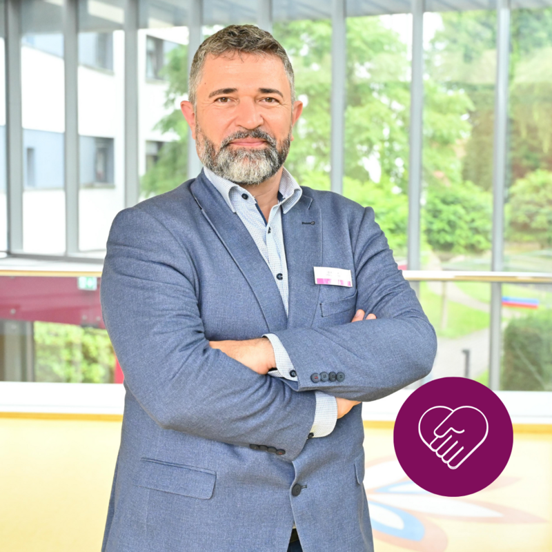 Mann in dunkelblauen Anzug lächelt sympathisch in der Klinik