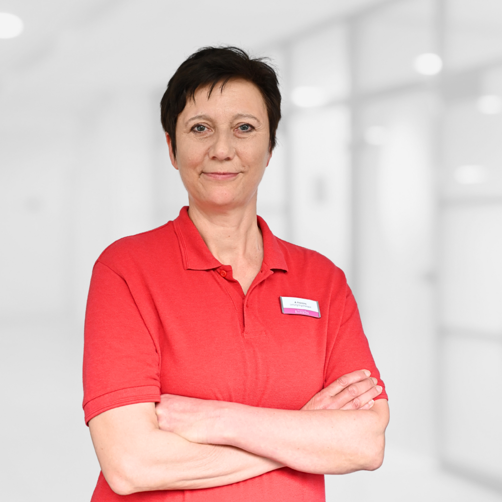 Dame mittleren Alters mit dunklen kurzen Haaren in rotem T-Shirt.