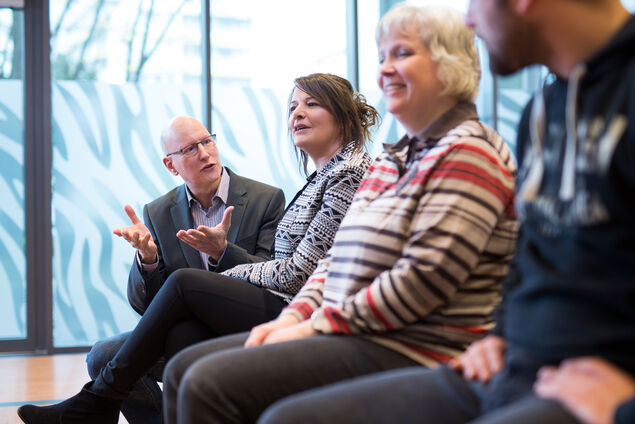 Gruppentherapie-Situation mit lachenden Patienten und Therapeuten