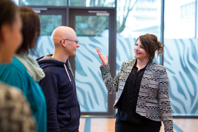 Therapeutin spricht lächelnd mit Patienten in Gruppensitzung